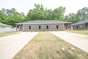 Phenix City house for rent - A large building with a grey roof and a long driveway in front.