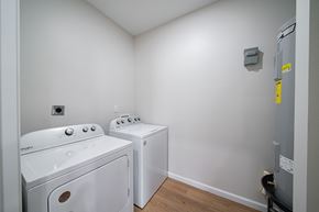 Phenix City house for rent - A small laundry room with a washer and dryer.