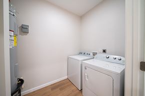 Phenix City house for rent - A small laundry room with a washer and dryer.