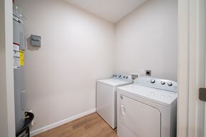 Phenix City house for rent - A small laundry room with a washer and dryer.