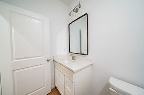 Phenix City house for rent - A white bathroom with a sink and mirror.