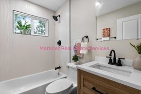 Denver house for rent - A bathroom with a white tub, sink, and toilet.