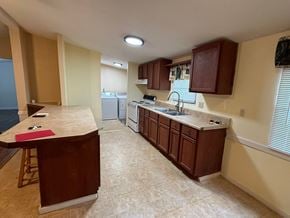 Fort Mccoy house for rent - A kitchen with brown cabinets and a counter.