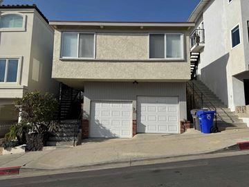 Manhattan Beach apartment for rent - A two-story beige house with a white garage door and a blue trash bin outside.