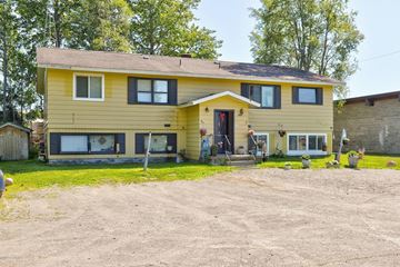 Kenai apartment for rent - A yellow house with a red door and a brown roof.