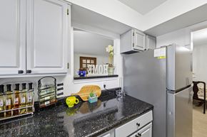 Silver Spring apartment for rent - A kitchen with a black counter top and white cabinets.