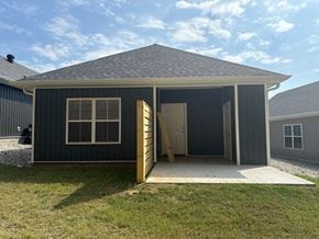 Little Rock house for rent - A small house with a grey roof and a grey exterior is shown with the door open.