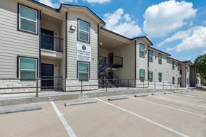 San Antonio apartment for rent - The image shows a multi-story building with a parking lot in front of it.