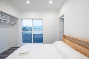 Los Angeles apartment for rent - A bedroom with a large bed and a view of the outside.