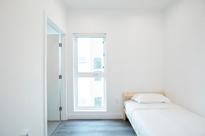 Los Angeles apartment for rent - A white bedroom with a bed and a window.