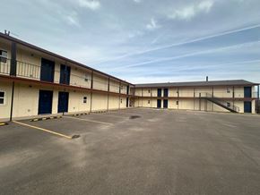 Big Spring apartment for rent - A large, empty parking lot in front of a building with multiple garage doors.