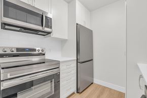 Cambridge apartment for rent - A modern kitchen with stainless steel appliances and white cabinetry.