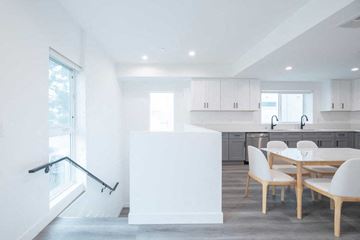 Los Angeles apartment for rent - A white kitchen with a table and chairs.