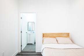 Los Angeles apartment for rent - A white bedroom with a bed and a mirror.