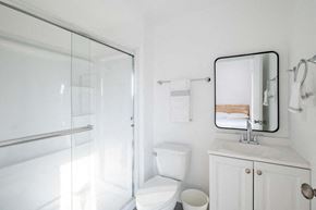 Los Angeles apartment for rent - A white bathroom with a toilet, sink, and mirror.