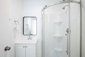 Los Angeles apartment for rent - A white bathroom with a sink, mirror, and shower.