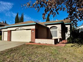 Roseville house for rent - A house with a garage door and a tree in front.