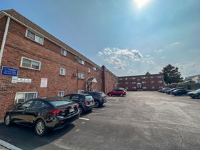 Bridgeport apartment for rent - A red brick building with a white awning and a sidewalk in front.