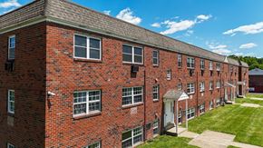 Morrisville apartment for rent - A large brick apartment building with a parking lot in front.