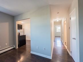 Bridgeport apartment for rent - A long hallway with a door on the right and a cabinet on the left.