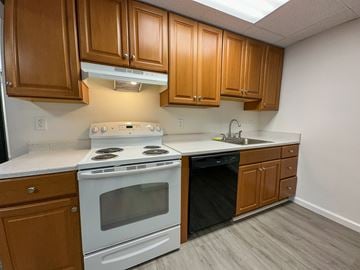 Sellersville apartment for rent - A kitchen with a white stove and wooden cabinets.