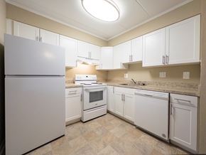 Prospect Park apartment for rent - A red brick building with a balcony and bushes in front.