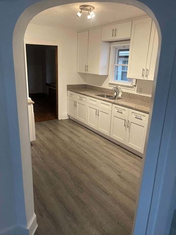 Akron house for rent - A kitchen with white cabinets and a window.