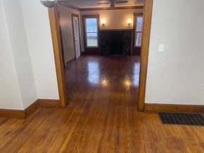 Akron house for rent - A room with wooden floors and a fireplace.