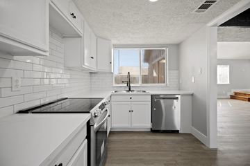 Missouri City house for rent - A modern kitchen with white cabinets and appliances.