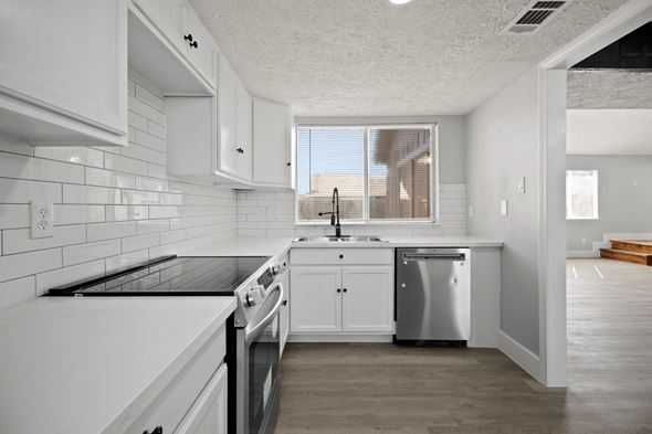 Missouri City house for rent - A modern kitchen with white cabinets and appliances.