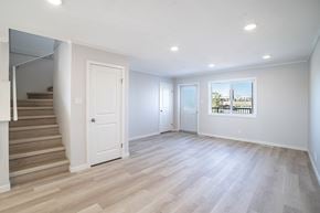 Saskatoon apartment for rent - A spacious room with light wood flooring and white walls.