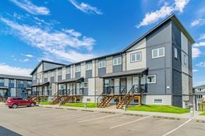 Saskatoon apartment for rent - A modern apartment building with a parking lot in front.