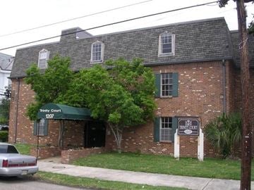 New Orleans apartment for rent - A brick building with a green awning that says "Pinety Court" on it.