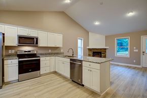 Boone house for rent - A kitchen with white cabinets and a wooden floor.