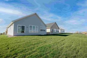 Hastings house for rent - Two houses are situated on a grassy field.