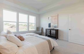 Hastings house for rent - A bedroom with a large bed and a chair by the window.
