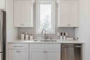 Hastings house for rent - A kitchen with white cabinets and a stainless steel dishwasher.