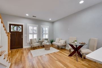 Nashville house for rent - A living room with a wooden floor and a dining table set up.