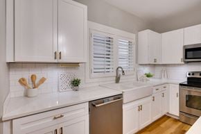 Nashville house for rent - A kitchen with white cabinets and a stainless steel dishwasher.