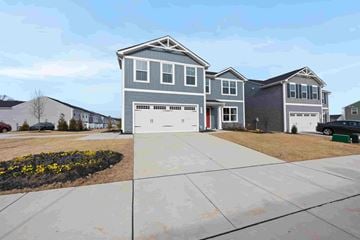 Raleigh house for rent - A grey house with a red door is in front of a row of houses.