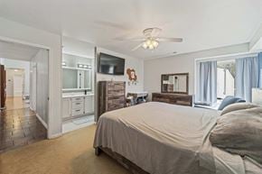 Jacksonville house for rent - A bedroom with a large bed and a ceiling fan.