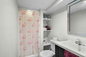 Grand Rapids house for rent - A bathroom with a toilet, sink, and shower curtain.