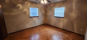 Harrah house for rent - A room with wooden flooring and two windows.