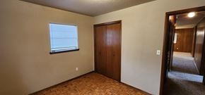 Harrah house for rent - A room with a wooden door and a window with blinds.