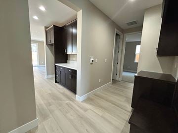 Manteca house for rent - A kitchen with black cabinets and a wooden floor.