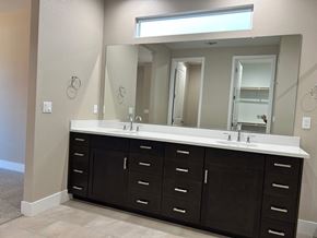 Manteca house for rent - A bathroom vanity with a white counter and black cabinets.