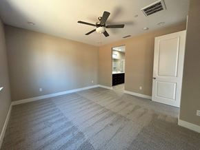 Manteca house for rent - A room with a ceiling fan and carpeted floor.