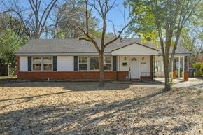 Montgomery house for rent - A small house with a white door and windows is surrounded by trees.
