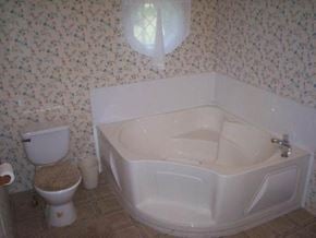 Spring Branch house for rent - A white toilet sits next to a white bathtub in a bathroom.