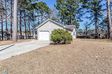 Midway Park house for rent - A house with a garage and a driveway surrounded by trees.